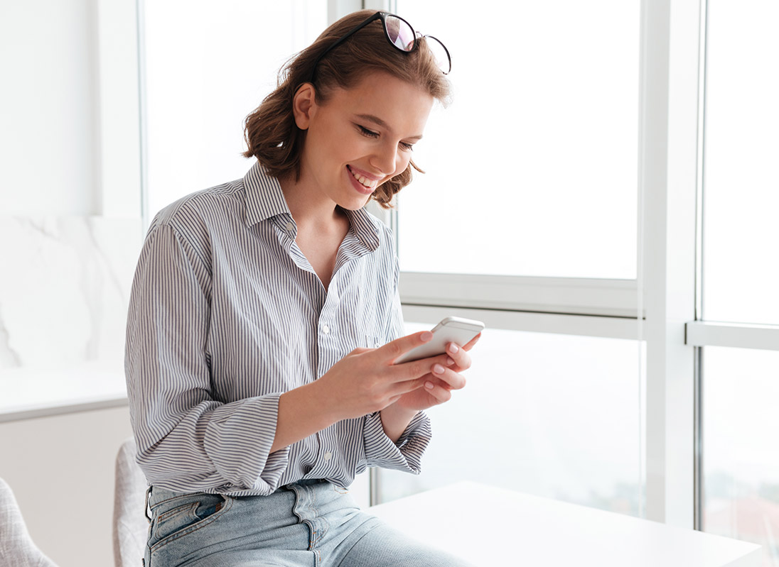 Une jeune femme utilise son téléphone cellulaire pour contacter CieNOV et obtenir des services-conseils pour son projet d'affaires dans la MRC de L'Assomption.